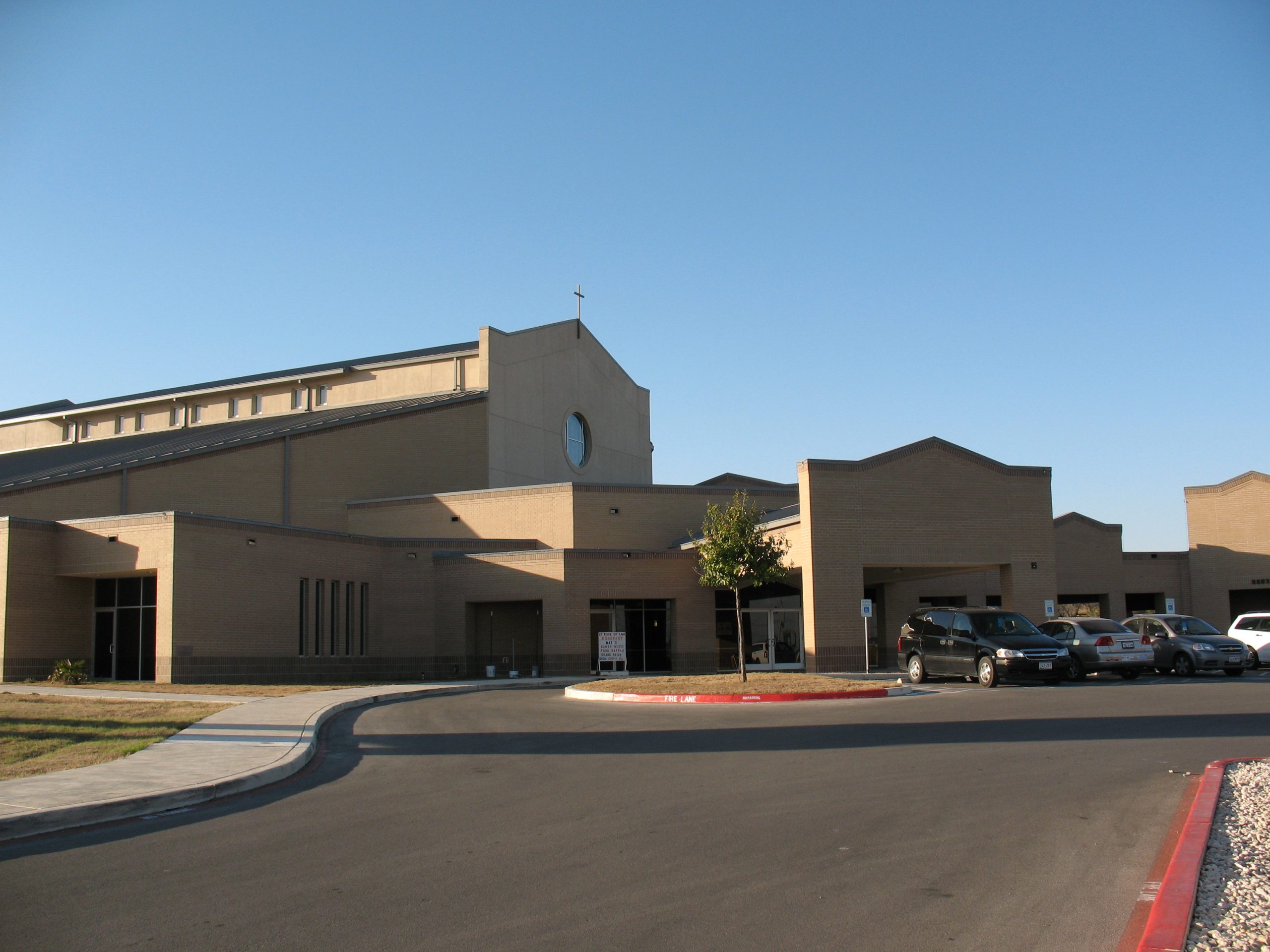 A large church with cars parked in front of it.