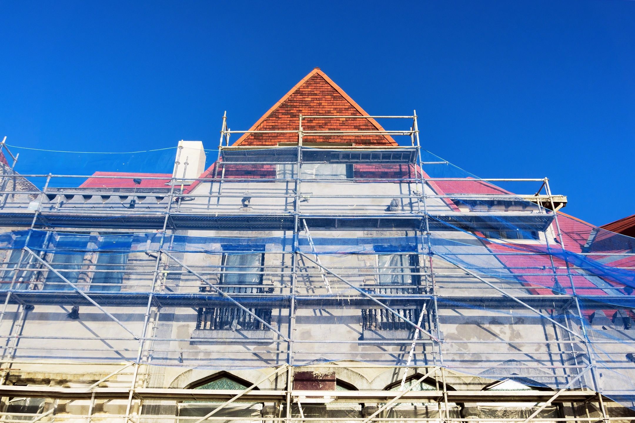 A building with scaffolding around it and a blue sky.