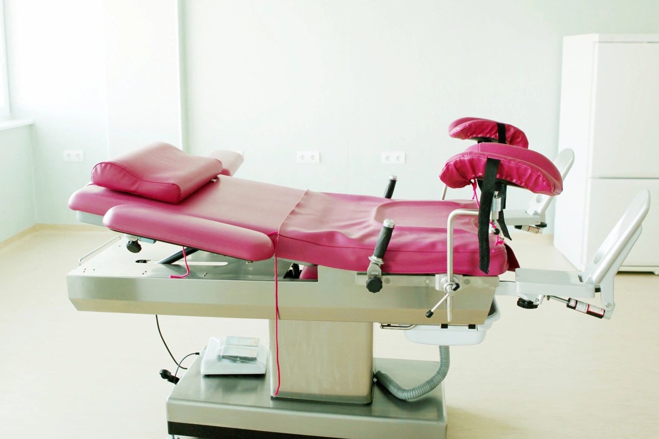 A pink chair and table in a room.