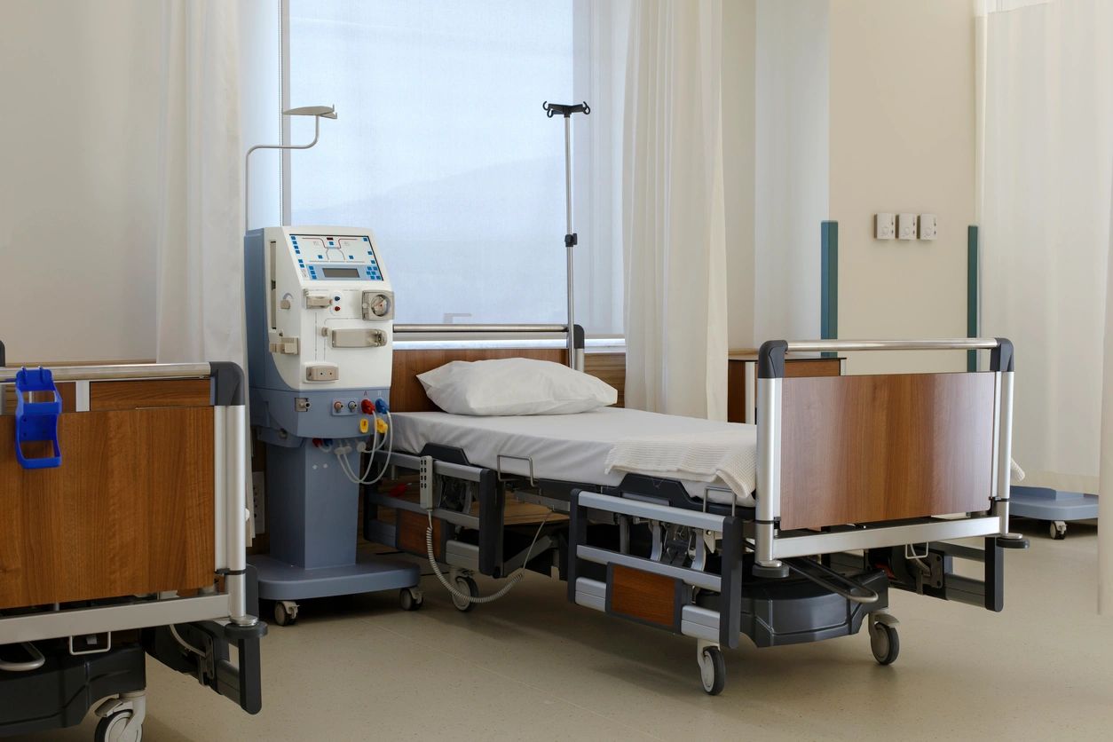 A hospital room with a bed and some medical equipment.