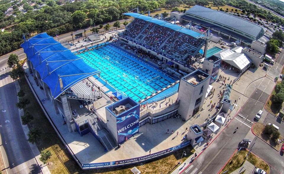 An aerial view of a swimming pool with many people in it.