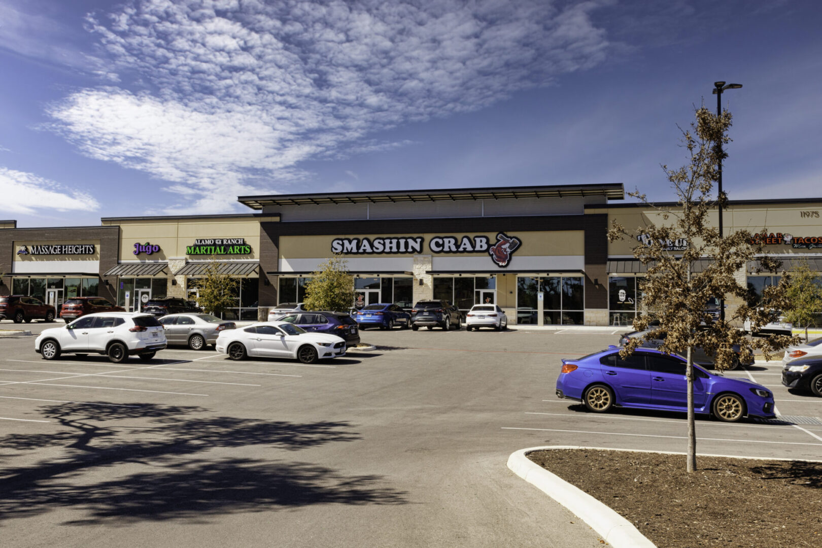 A parking lot with cars parked in front of it.